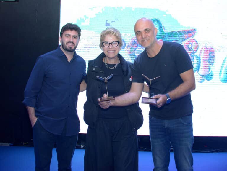 Momento da premiação: João Resegue, presidente do Grupo SIM, ladeado por Mônica Debanné e Louis Debanné, ambos MP Publicidade.