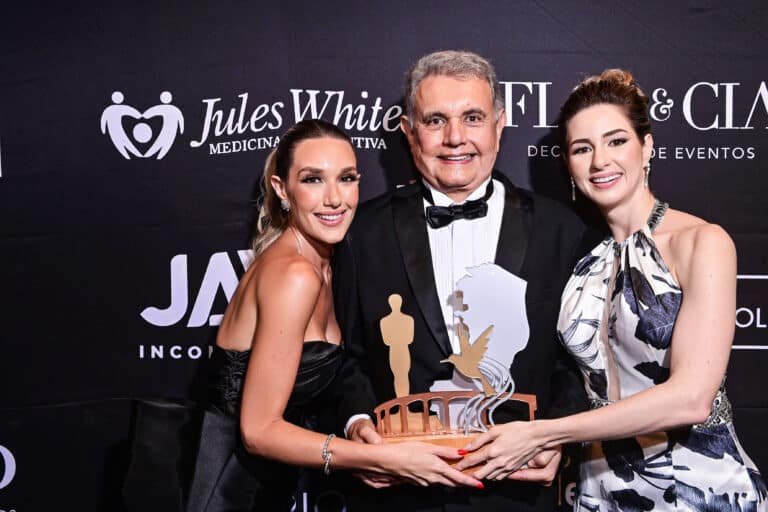 Um momento de honra: Dr. Jules White,  ao lado de suas  filhas Vicki e Cindy White, recebendo a merecida homenagem.