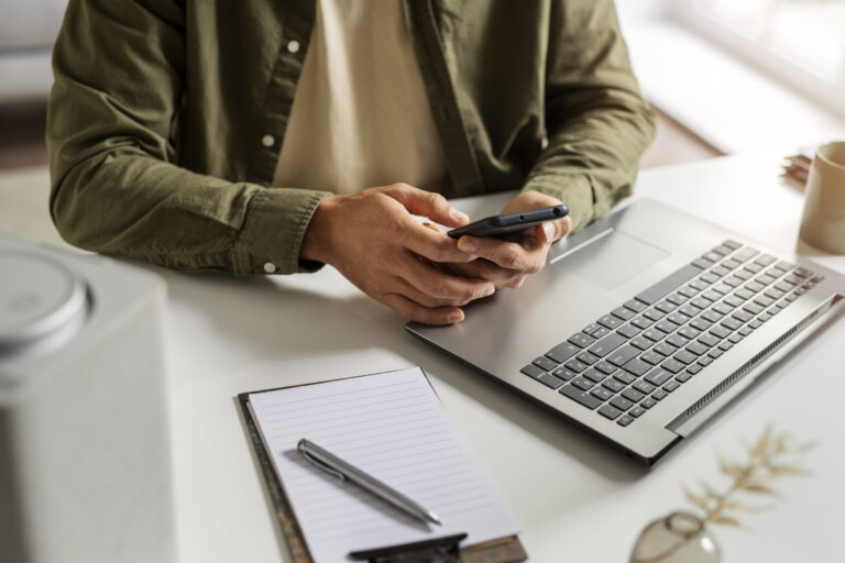 Pessoa usando notebook e celular