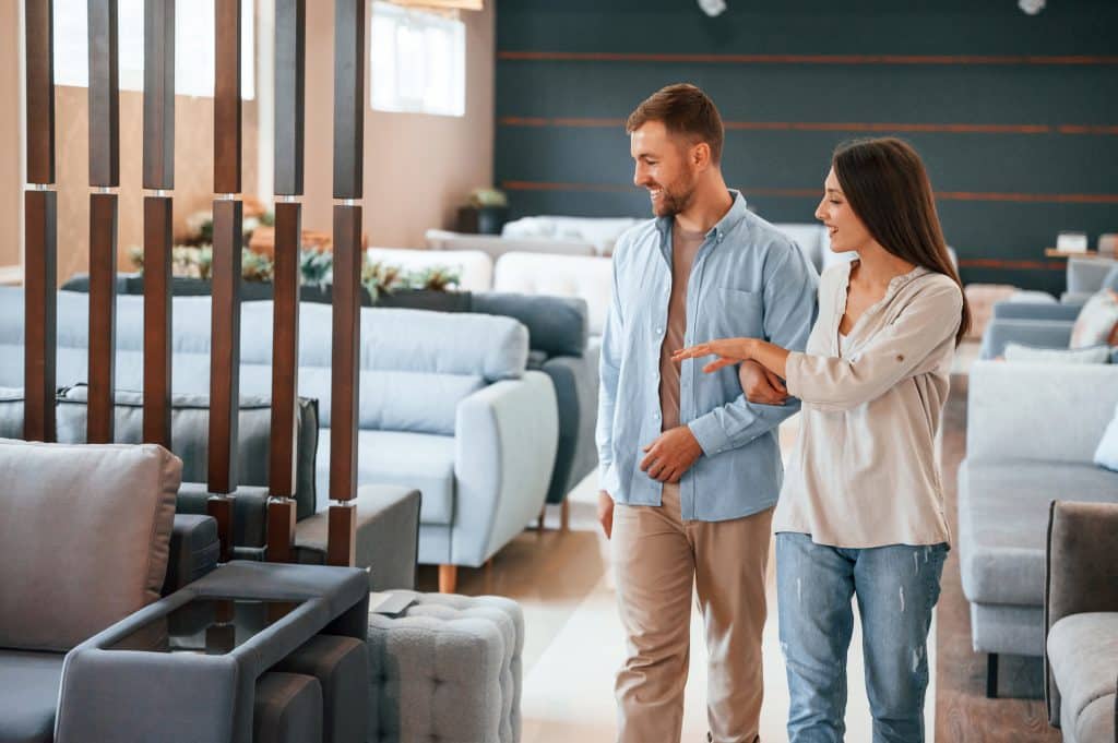 Walking around. Couple choosing the sofa and bed in the store