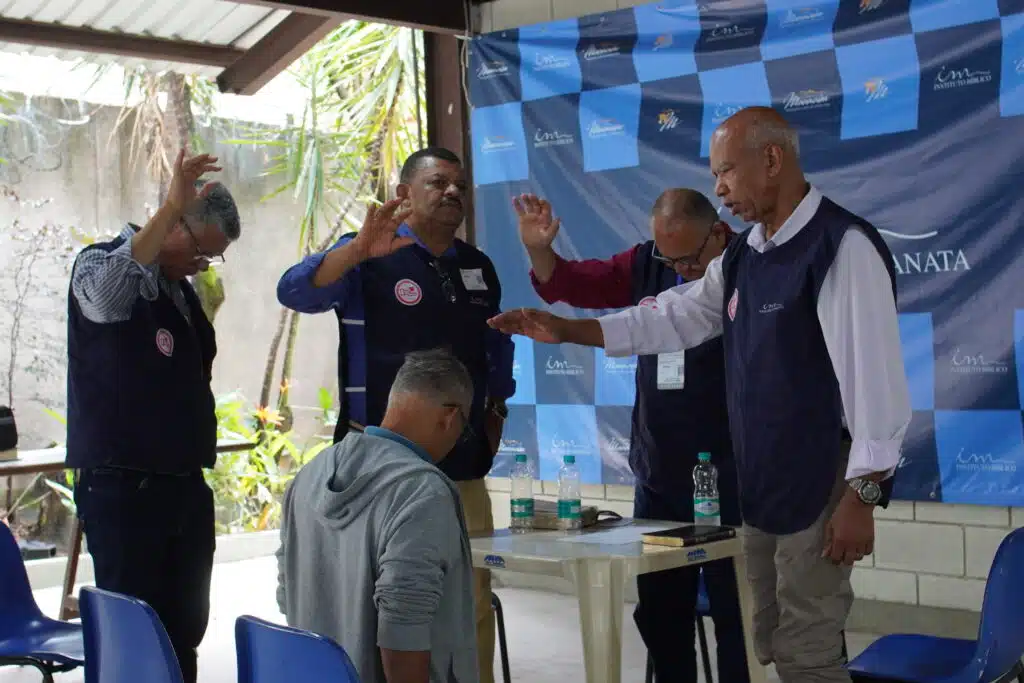 Voluntários realizam momento de oração durante ação social da Igreja Cristã Maranata